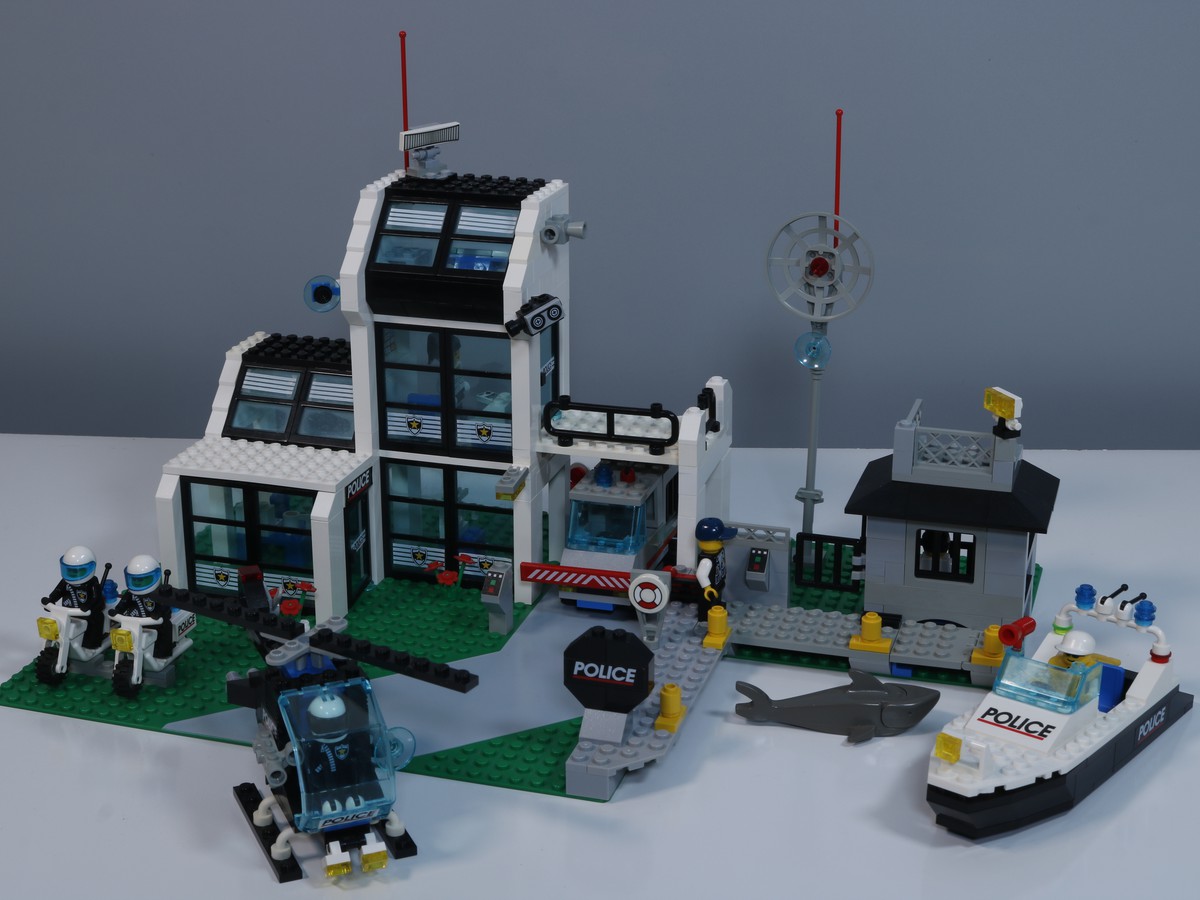 LEGO Police Station (set 6598), showing the various pieces including a police boat, police car, and minifigures dressed in police uniforms. 