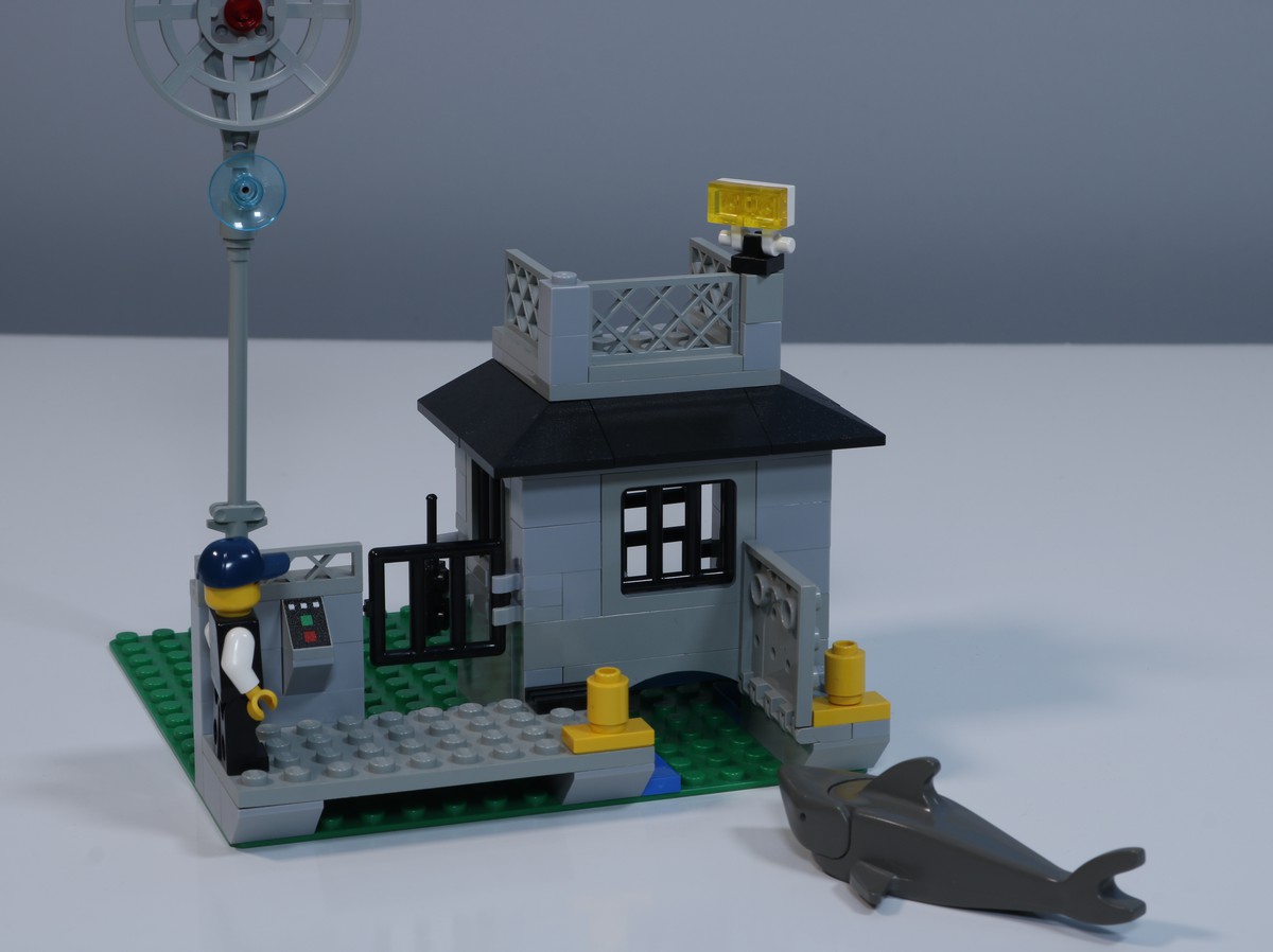 A image of the back of the jail cell from the LEGO Police Station (set 6598), decpicting a shark swimming near the back of the cell. 