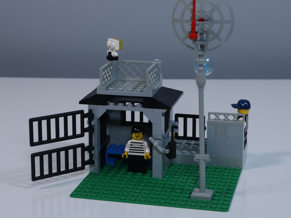 A image of the front of the jail cell from the LEGO Police Station (set 6598), showing an open cell door where a criminal minigure stands. 